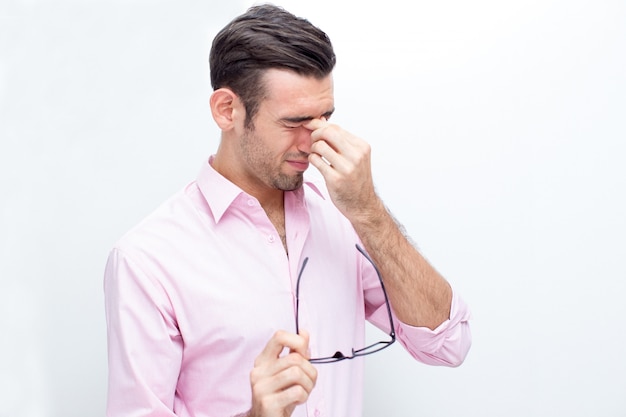 Hombre de negocios cansado que toca el puente de la nariz