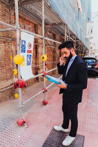 Hombre de negocios con carpeta hablando por teléfono