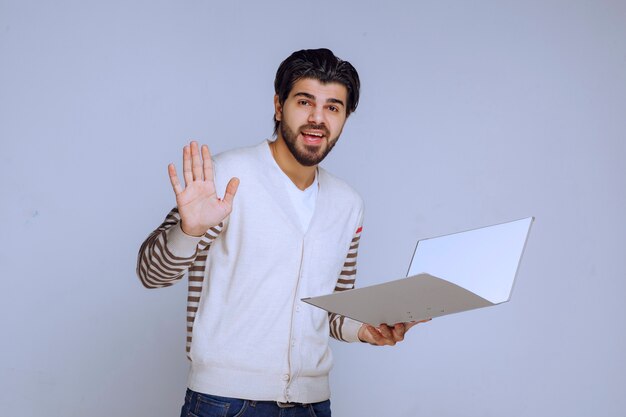 Hombre de negocios con una carpeta de proyecto dando la mano y saludando a sus colegas.