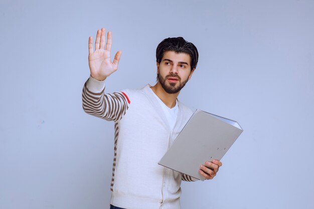 Hombre de negocios con una carpeta de proyecto dando la mano y saludando a sus colegas.