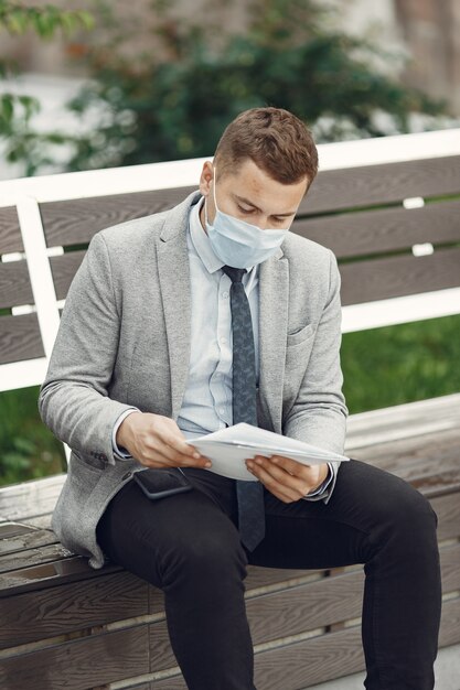 Hombre de negocios en una ciudad. Persona con máscara.