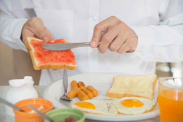 El hombre de negocios come el desayuno americano fijado en un hotel