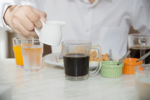 El hombre de negocios come el desayuno americano fijado en un hotel