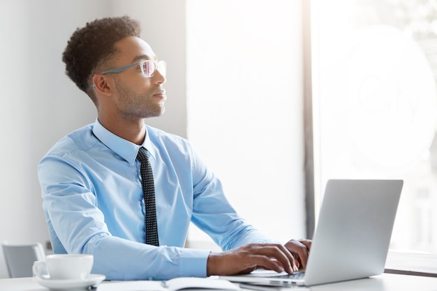 Hombre de negocios confiado trabajando en su computadora portátil