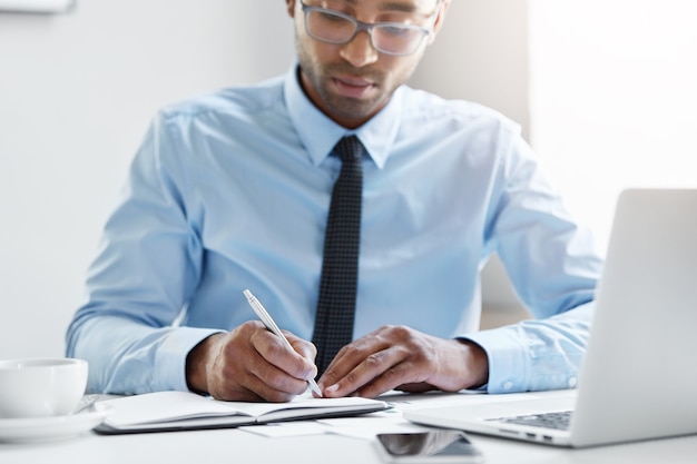 Hombre de negocios confiado trabajando en su computadora portátil