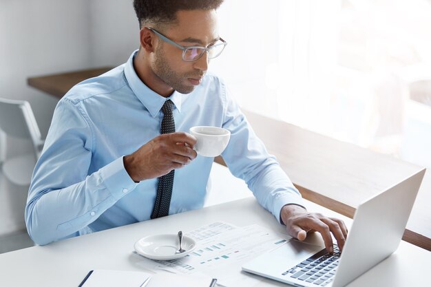 Hombre de negocios confiado trabajando en su computadora portátil