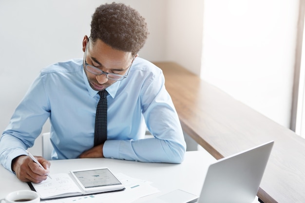 Hombre de negocios confiado trabajando en su computadora portátil