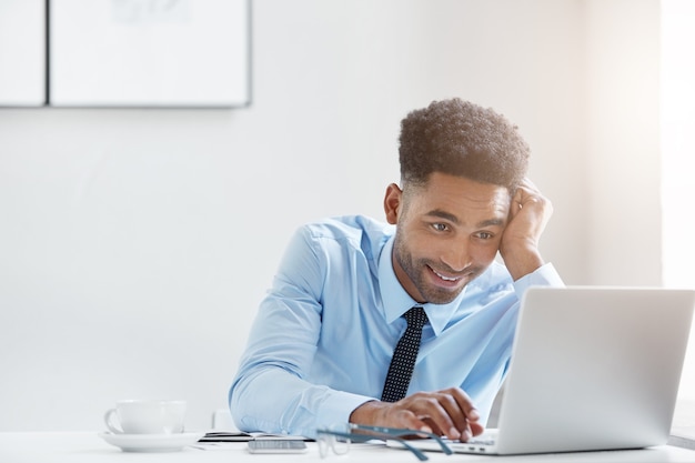 Hombre de negocios confiado trabajando en su computadora portátil