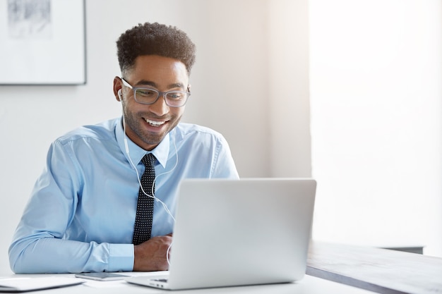 Hombre de negocios confiado trabajando en su computadora portátil