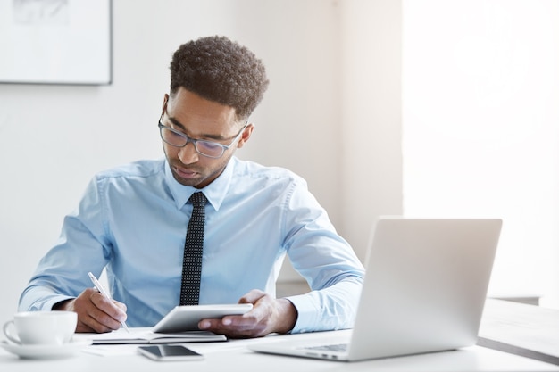 Hombre de negocios confiado trabajando en su computadora portátil