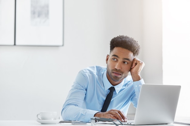 Hombre de negocios confiado trabajando en su computadora portátil