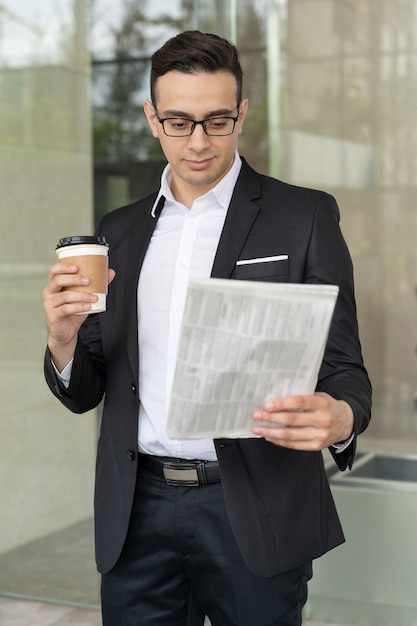 Hombre de negocios confidente que mira a través de noticias