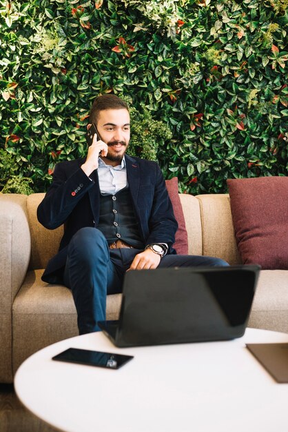 Hombre de negocios contenido talkign en teléfono en café