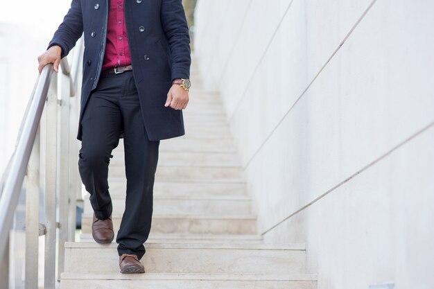 Hombre de negocios elegante con abrigo bajando