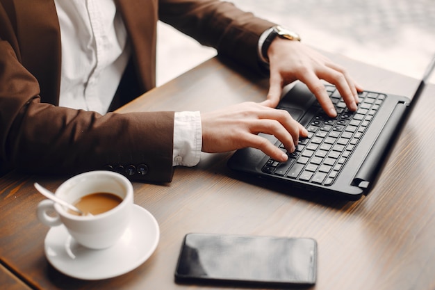 Hombre de negocios elegante que trabaja en un café