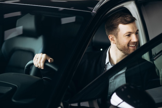 Hombre de negocios eligiendo un automóvil en el salón del automóvil