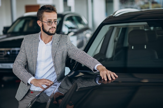 Foto gratuita hombre de negocios eligiendo un coche en una sala de exposición de coches