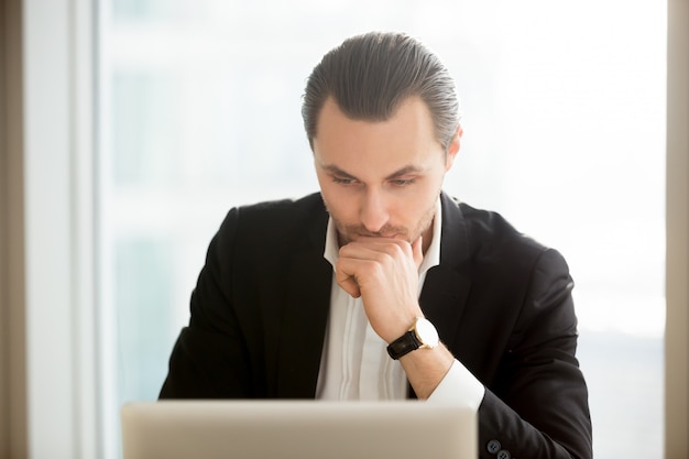 Hombre de negocios enfocado buscando solución en internet