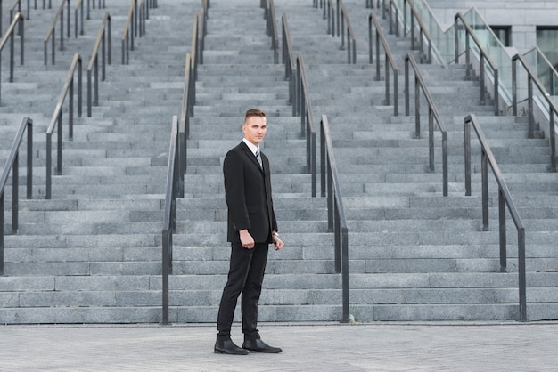 Foto gratuita hombre de negocios enfrente de escaleras