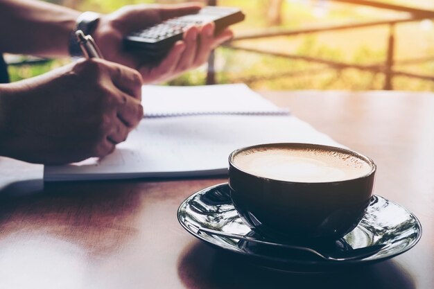 El hombre de negocios está trabajando con su computadora en cafetería