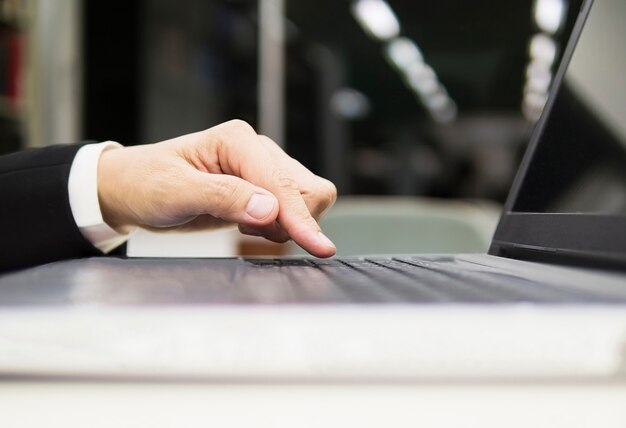 Hombre de negocios está utilizando la computadora portátil en su oficina