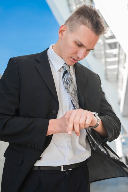 Hombre de negocios con estilo mirando a reloj