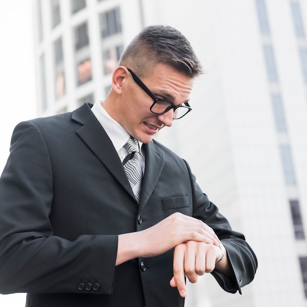 Foto gratuita hombre de negocios con estilo mirando a reloj