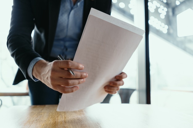 Hombre de negocios exitoso firmando documentos en una oficina moderna