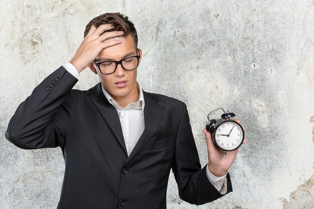 Hombre de negocios exitoso en ropa formal apuntando al reloj