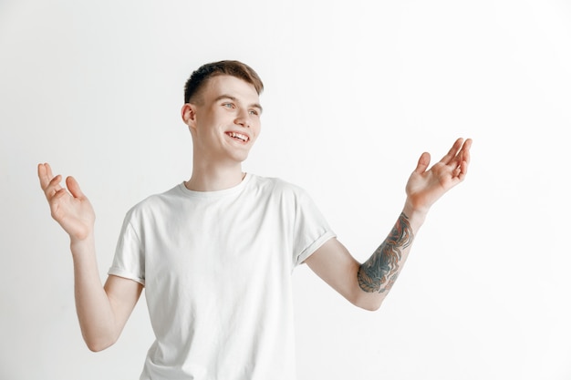 Hombre de negocios feliz de pie, sonriendo aislado en estudio gris