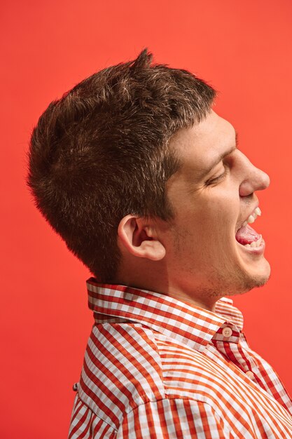 Hombre de negocios feliz de pie y sonriendo aislado en estudio rojo