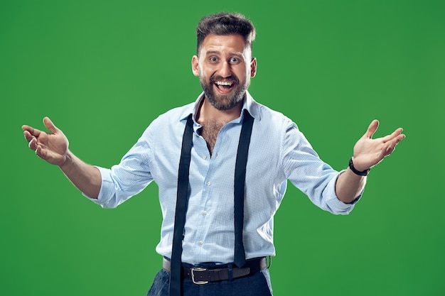 Foto gratuita hombre de negocios feliz de pie y sonriendo aislado en la pared verde del estudio