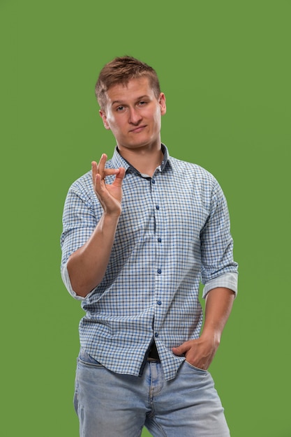 hombre de negocios feliz de pie y sonriendo contra el verde