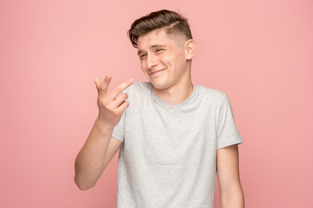 El hombre de negocios feliz de pie y sonriente contra el espacio de color rosa.