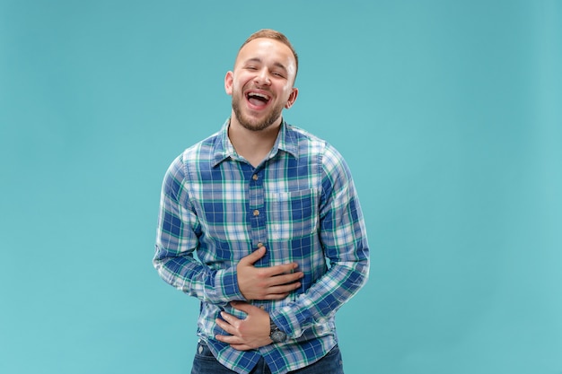 El hombre de negocios feliz de pie y sonriente contra rosa.