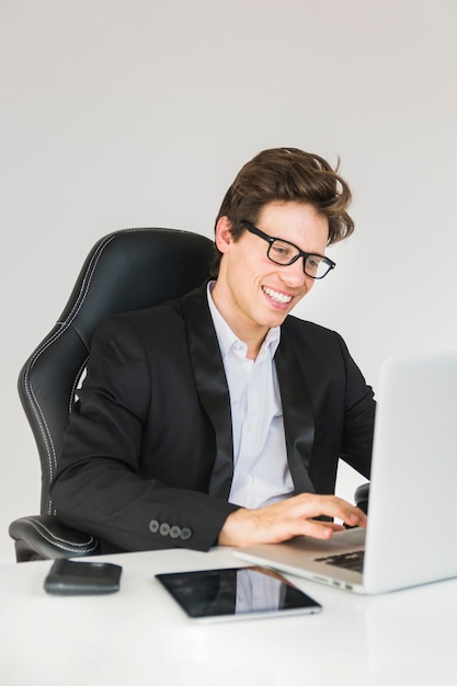 Hombre de negocios feliz trabajando en la computadora portátil en la oficina