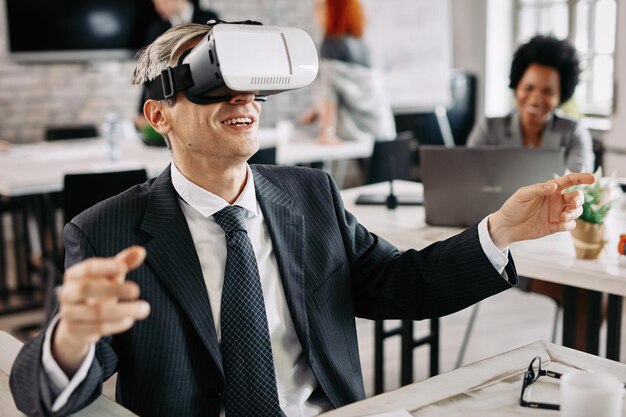 Hombre de negocios feliz usando un simulador de realidad virtual y divirtiéndose en el trabajo