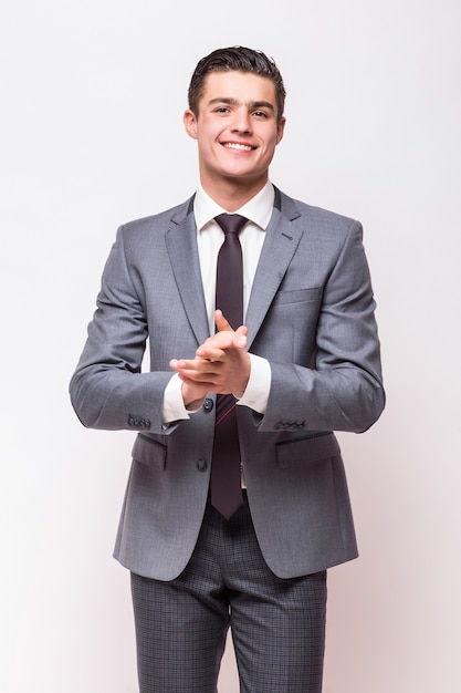 Foto gratuita hombre de negocios feliz vestido con traje gris que se encuentran aisladas en la pared blanca