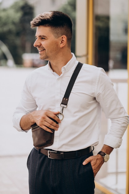 Hombre de negocios guapo en camisa blanca afuera