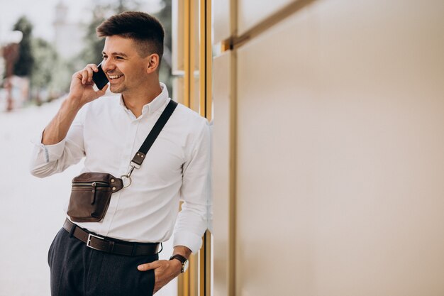 Hombre de negocios guapo en camisa blanca afuera