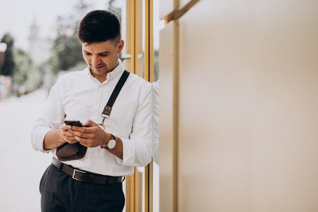 Hombre de negocios guapo en camisa blanca afuera