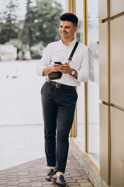 Hombre de negocios guapo en camisa blanca afuera