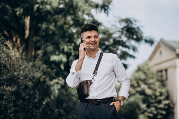 Hombre de negocios guapo en camisa blanca afuera