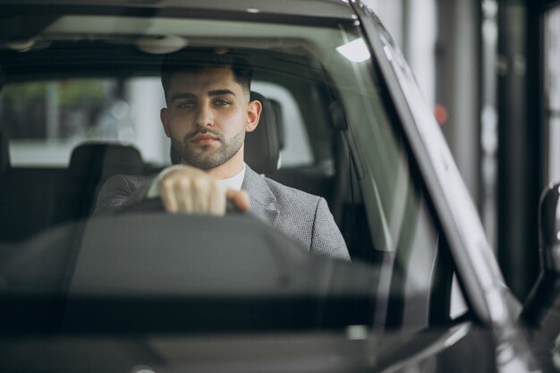 Hombre de negocios guapo conduciendo en coche