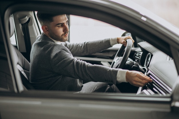 Hombre de negocios guapo conduciendo en coche