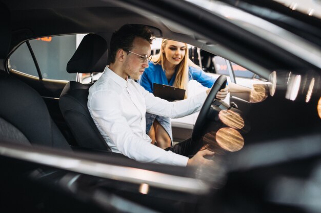 Hombre de negocios guapo elegir un automóvil en una sala de exposición de automóviles