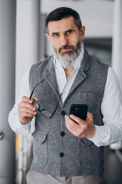 Hombre de negocios guapo hablando por teléfono en la oficina