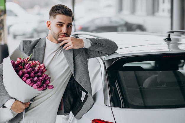 Hombre de negocios guapo joven que entrega ramo de flores hermosas