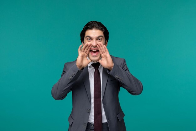 Hombre de negocios guapo lindo chico morena en traje de oficina gris y corbata gritando