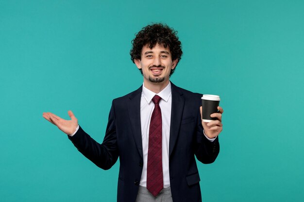 Hombre de negocios guapo lindo joven en traje negro y corbata roja feliz y sosteniendo una taza de café